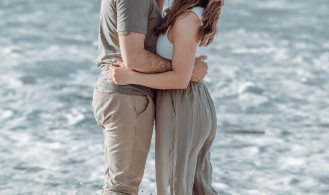 ww_upload_Raquel_y_Aitor_by__wandaweddings-65 Pareja besándose mientras rompe una ola en su sesión de preboda en la playa